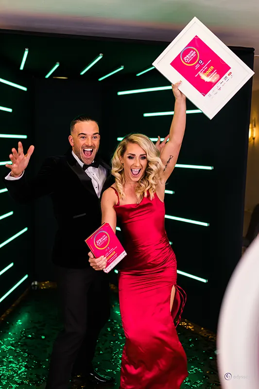 Two excited guests celebrating with awards at a corporate awards evening